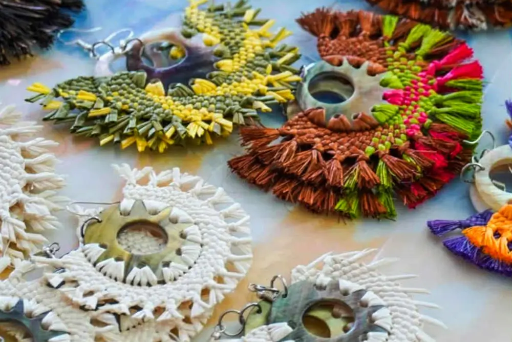 Handwoven earrings in Rarotongan style on a table, for sale